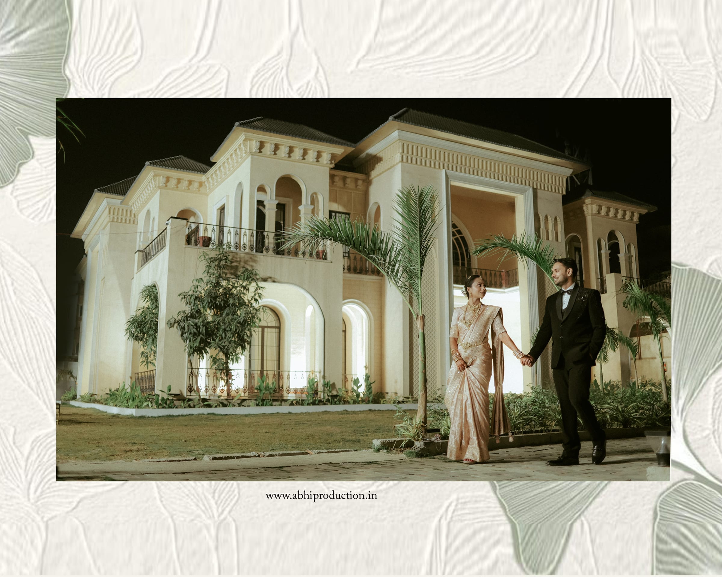 The couple walking hand in hand before a floodlit mansion and palms at night