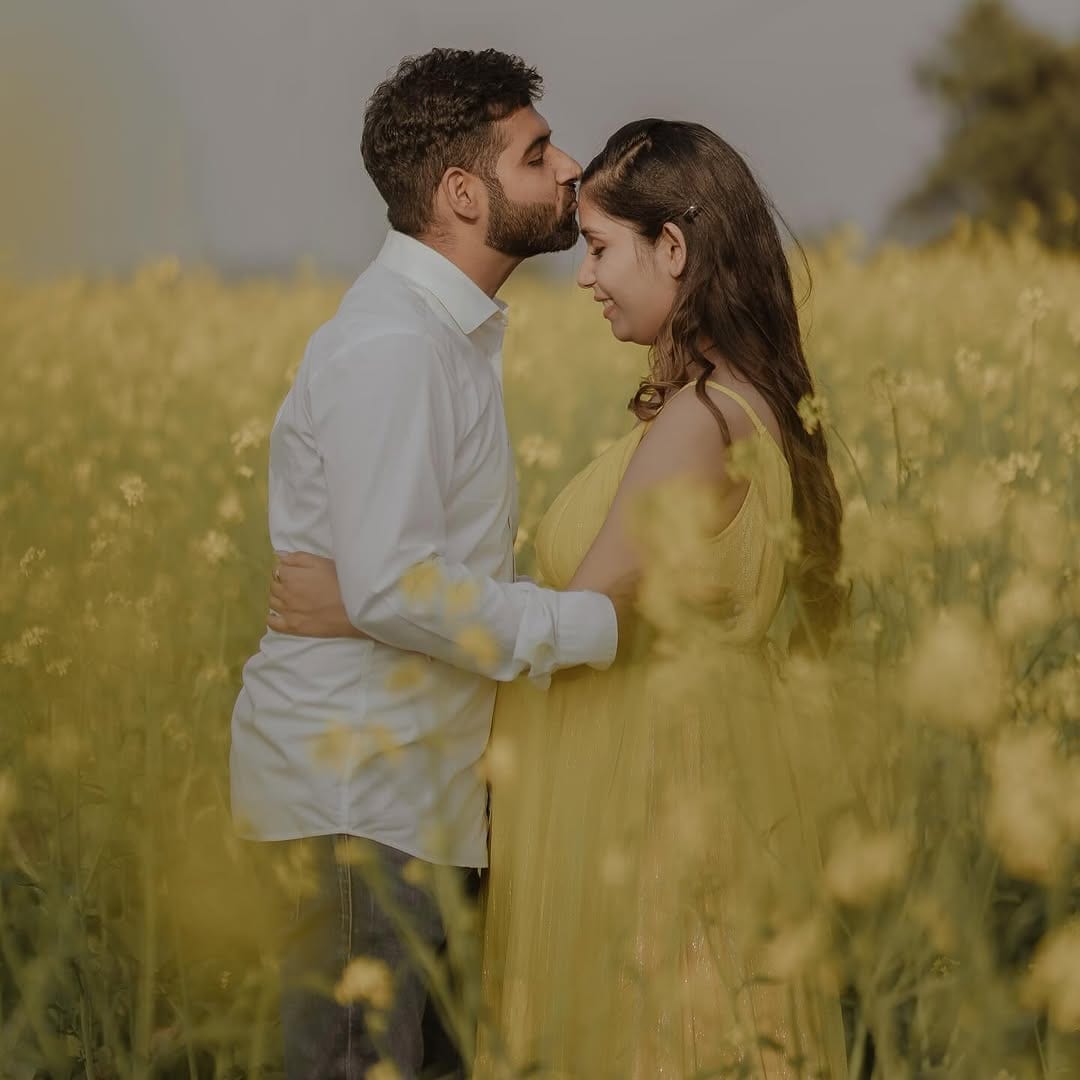 The couple forehead to forehead in a mustard field