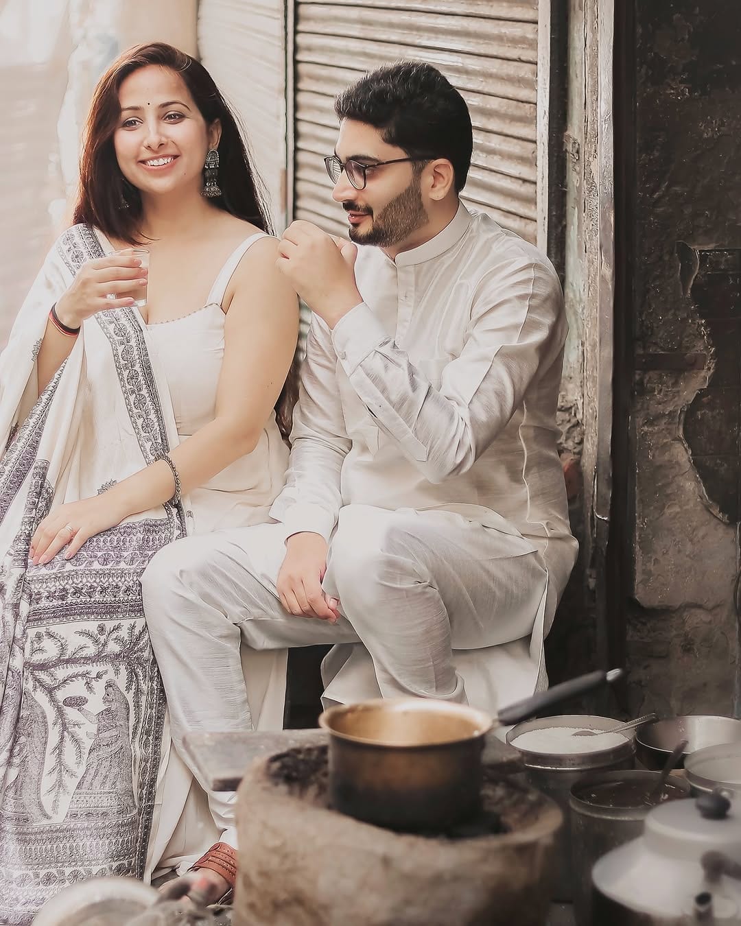 The couple in white, sitting outside a shuttered shopfront