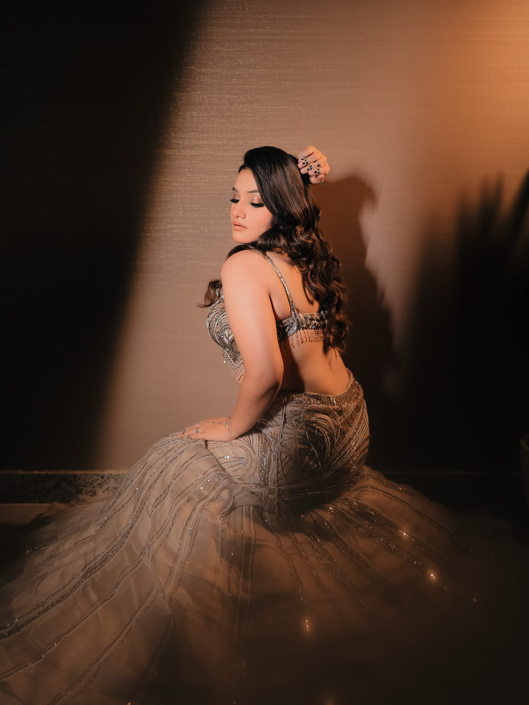 A seated back-view portrait, the tulle skirt fanned across the floor