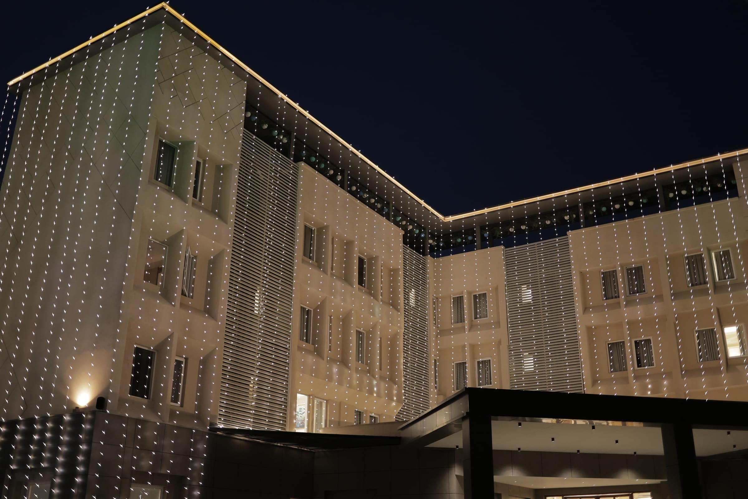 The building façade curtained in fairy lights at dusk