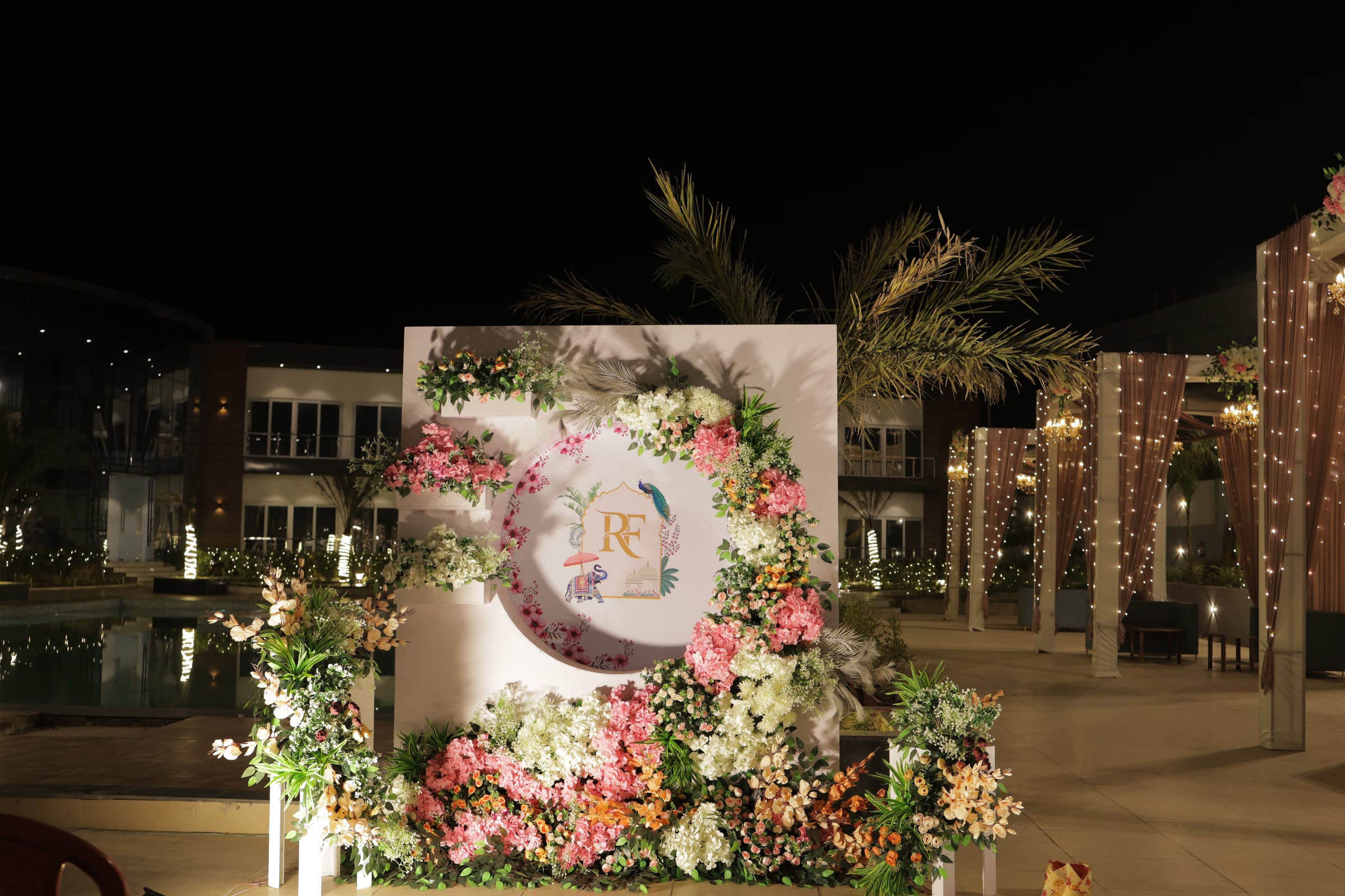 A monogrammed welcome board framed in flowers at the entrance