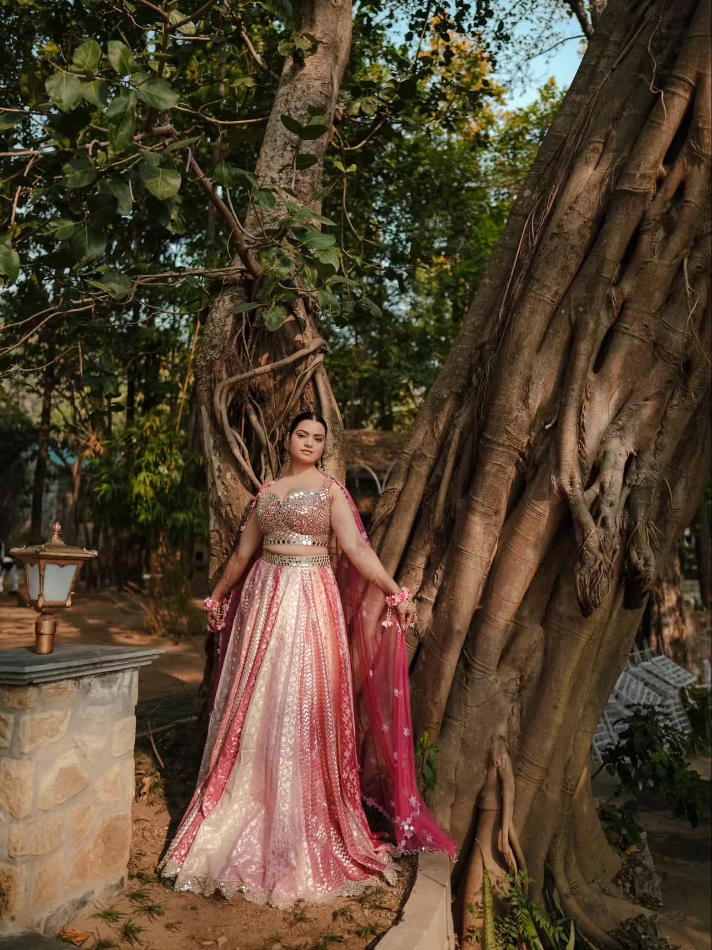 The bride standing among the aerial roots of a banyan