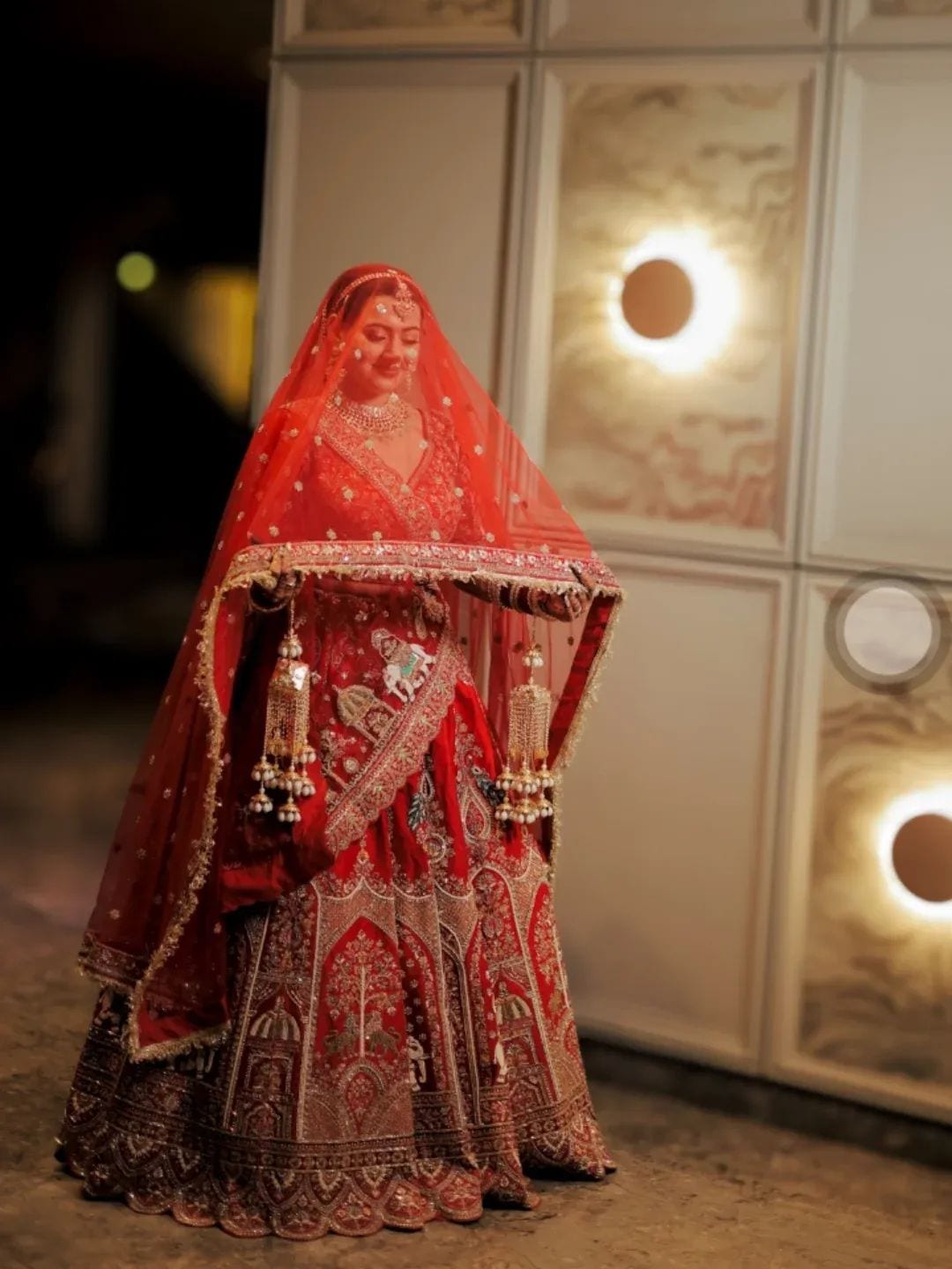 The bride beneath her red veil before the ceremony